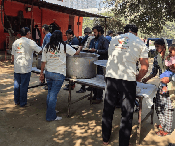 Volunteers serving hundreds of individuals from large community pots during an NCF mega food drive